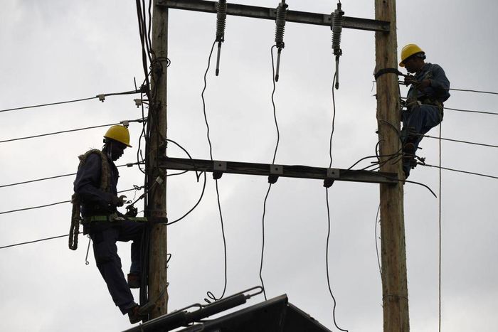 [FILE] Kenya Power and Lighting Company (KPLC) live line experts dismantle power cables to relocate power lines to pave way for the construction of the Nairobi Expressway in Westlands, Nairobi, on September 24, 2020. (Photo by SIMON MAINA/AFP via Getty...