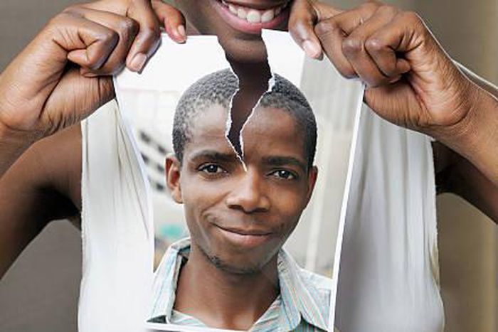 Young woman tearing a picture of a man - stock photo