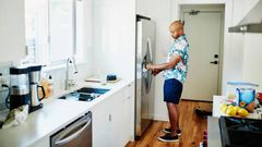 A man trying to move a fridge