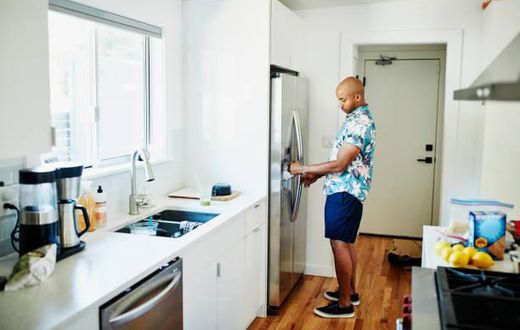 A man trying to move a fridge