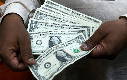 A Pakistani man counts US dollars at the currency exchange place in Lahore on May 16, 2019; meanwhile, gas stations in Lebanon are paid by customers in Lebanese pounds but must pay suppliers in US dollars