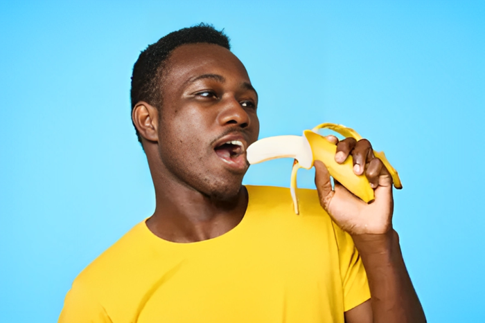 African man eating a banana