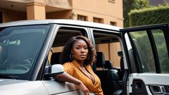 An AI-generated image of a very beautiful African lady coming out of a Range Rover