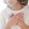 A stock image shows a woman clutching her chest.Science Photo Library/Getty Images