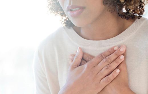 A stock image shows a woman clutching her chest.Science Photo Library/Getty Images