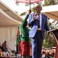 Young learner holding an umbrella for CS Machogu during a public function in Murang'a