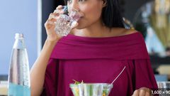 Lady drinking while eating