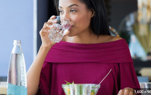 Lady drinking while eating