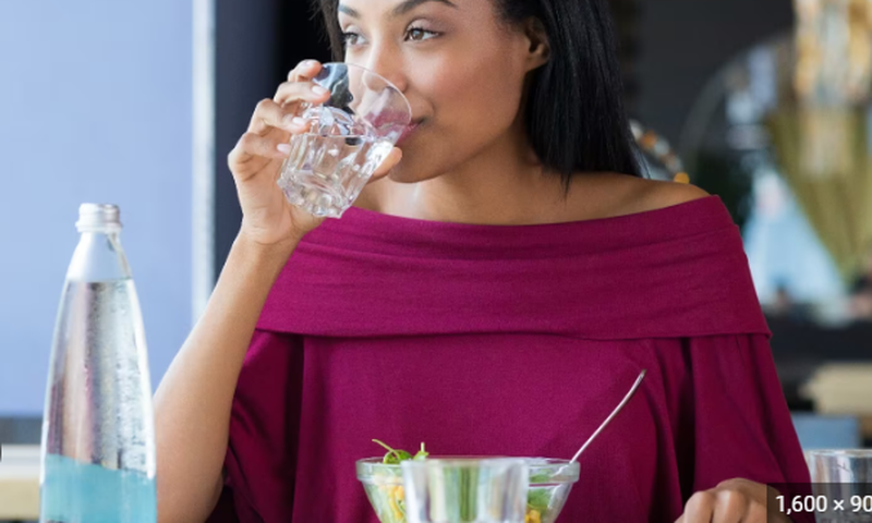 Lady drinking while eating