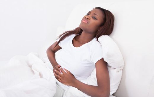 ___7975596___2018___2___13___9___a-woman-is-lying-in-bed-holding-her-stomach