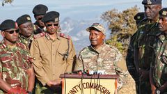 Interior CS Kithure Kindiki addressing the media while flanked by security bosses