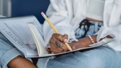 Woman writing with pencil in notebook [Photo: Zen Chung]