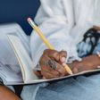 Woman writing with pencil in notebook [Photo: Zen Chung]