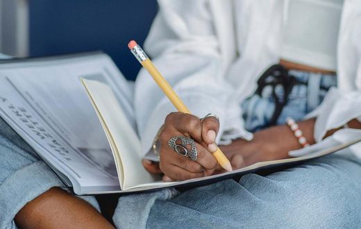 Woman writing with pencil in notebook [Photo: Zen Chung]