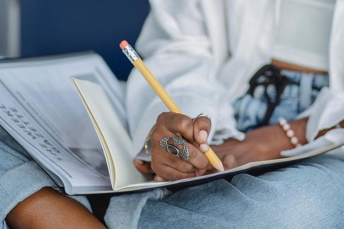 Woman writing with pencil in notebook [Photo: Zen Chung]