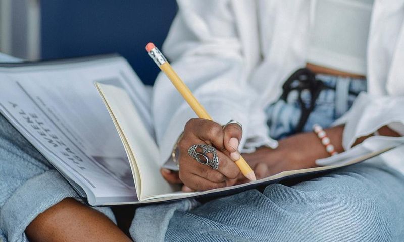 Woman writing with pencil in notebook [Photo: Zen Chung]