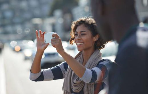 A lady taking a photo with her phone.[Photo: Klaus Vedfelt]