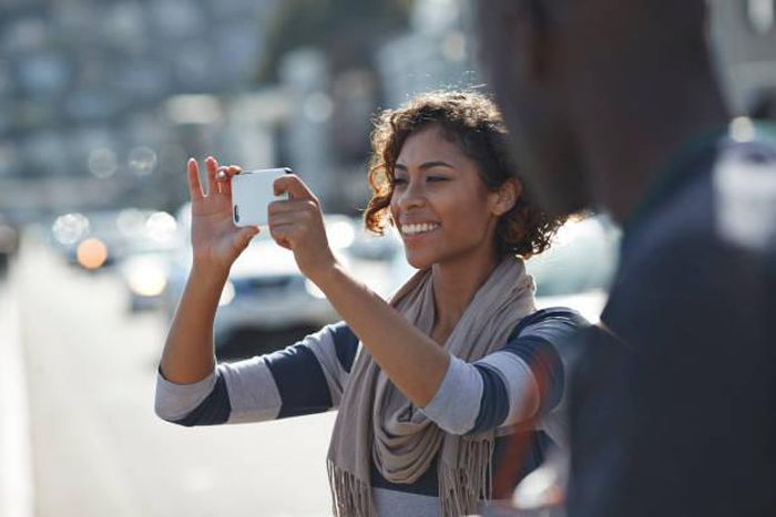 A lady taking a photo with her phone.[Photo: Klaus Vedfelt]