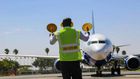 An aircraft marshal guides a plane at JKIA