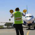 An aircraft marshal guides a plane at JKIA