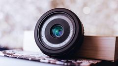 Canon zoom lens leaning on book [Image: Freestocks.org]