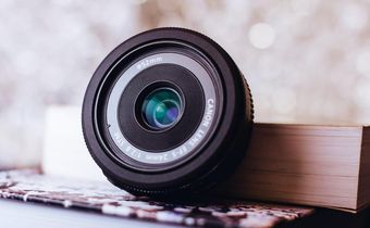 Canon zoom lens leaning on book [Image: Freestocks.org]