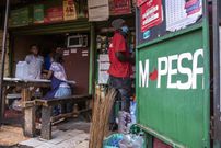 A Safaricom Plc M-Pesa mobile money service logo at a retail kiosk in central Nairobi, Kenya, on Tuesday, May 11, 2021. (Photographer: Patrick Meinhardt/Bloomberg via Getty Images)