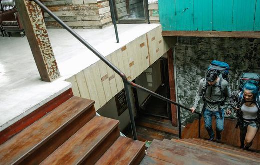 Couple of unrecognizable travelers with backpacks walking upstairs [Image credit: George Pak]
