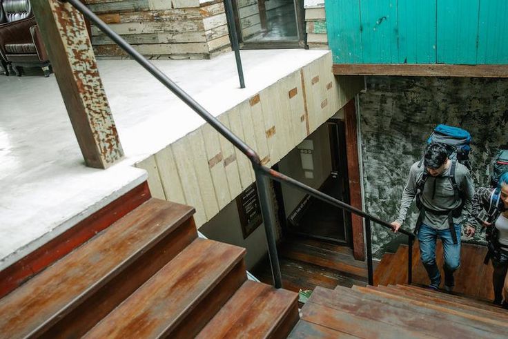 Couple of unrecognizable travelers with backpacks walking upstairs [Image credit: George Pak]