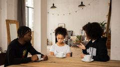 Black parents lecturing upset daughter at table [Credit: Monstera Production]
