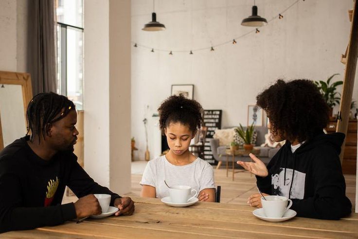 Black parents lecturing upset daughter at table [Credit: Monstera Production]