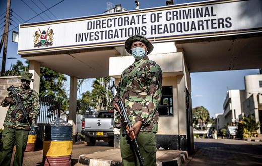 Police officers monitor the entrance to the DCI headquarters.  (Image- The Washington Post)