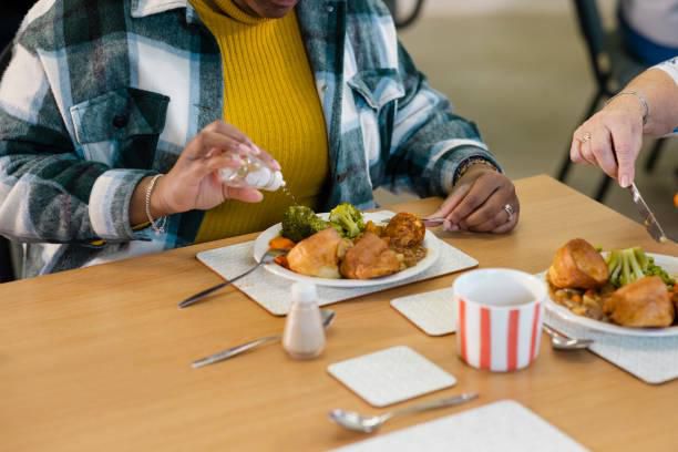 A person sprinkling salt to food