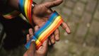 Man showing LGBTQIA ribbon on hand [Photo: Anete Lusina]