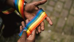 Man showing LGBTQIA ribbon on hand [Photo: Anete Lusina]