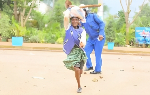 Viral photo of an elderly woman running past a police officer in Kisii during the Saba Saba protests (Courtesy)