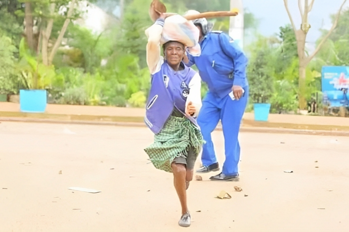 Viral photo of an elderly woman running past a police officer in Kisii during the Saba Saba protests (Courtesy)