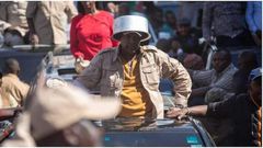 Azimio la Umoja leader Jeremiah Kioni puts a sufuria on his head during a past