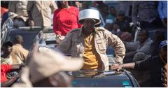 Azimio la Umoja leader Jeremiah Kioni puts a sufuria on his head during a past