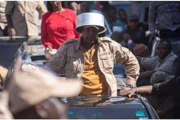 Azimio la Umoja leader Jeremiah Kioni puts a sufuria on his head during a past