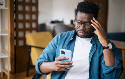 A man looking at his phone worried