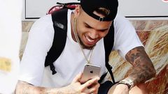 Chris Brown staring at his phone