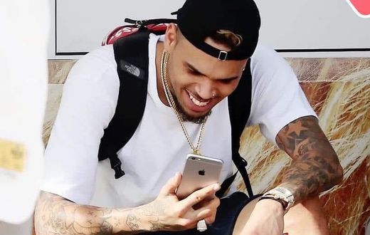 Chris Brown staring at his phone