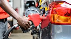 Attendant putting fuel in a car