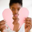Woman holding a broken paper heart