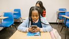 Girl sitting on her desk while using her smartphone [Image: RDNE Stock Project]