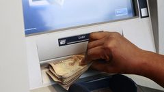 A woman takes Nigerian Naira from a bank's automated teller machine (ATM) in Ikeja district in the commercial capital Lagos November 12, 2014.