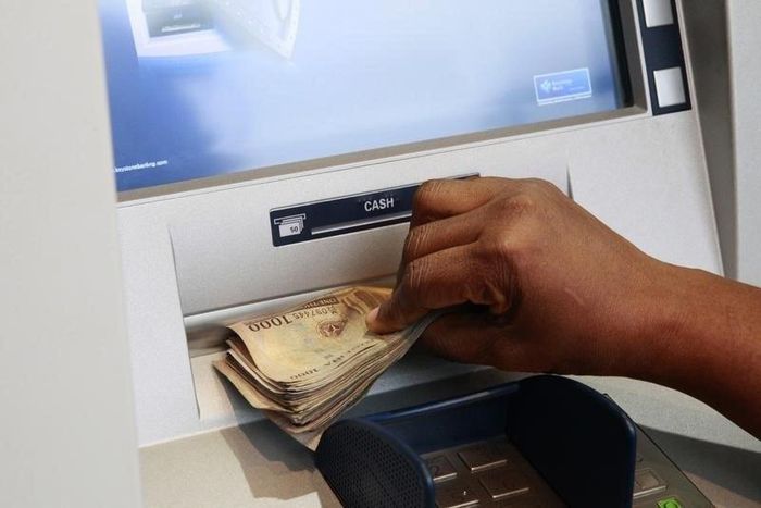 A woman takes Nigerian Naira from a bank's automated teller machine (ATM) in Ikeja district in the commercial capital Lagos November 12, 2014.