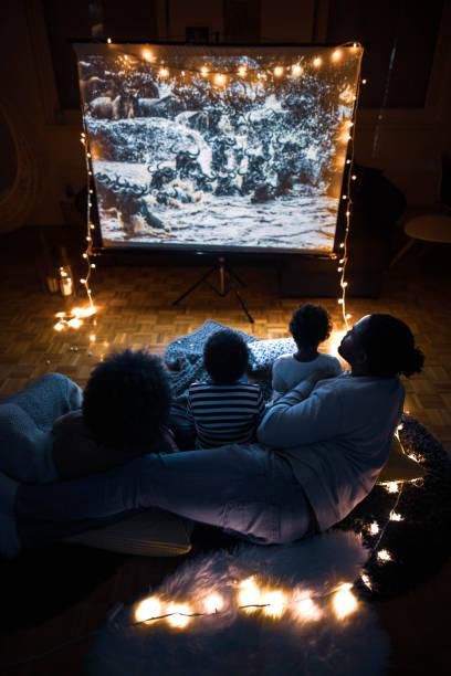 A family watching a movie on a projection screen at home