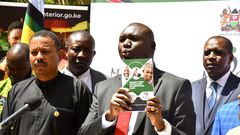 Immigration and Citizen Services PS Julius Bitok displays a copy of a booklet on Frequently Asked Questions (FAQs) on Digital ID to the media at the Nairobi Serena Hotel. Looking on is Amnesty International Kenya Executive Director Irungu Houghton